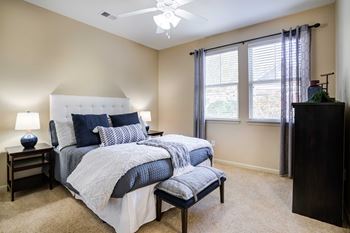 A bedroom with a bed and a ceiling fan